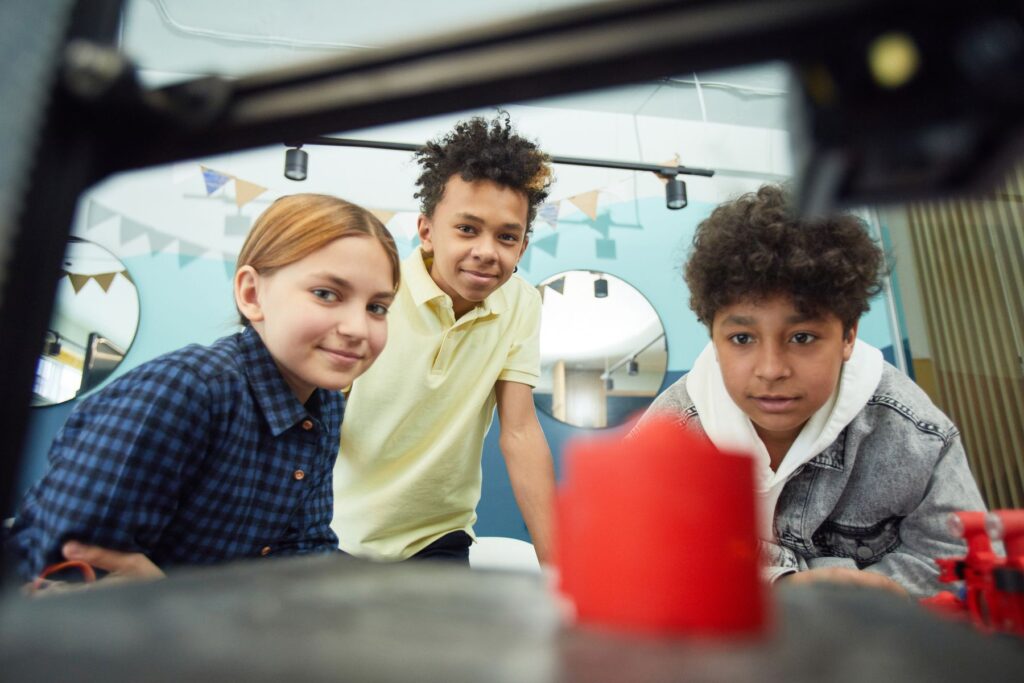 Children observing a 3D printer in a workshop